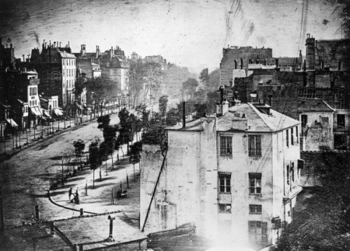 First photograph of a human, ‘Boulevard du Temple’, Paris, 1838. Boulevard du Temple, taken by Louis  Daguerre in late 1838,  was the first-ever photograph of a person. It is an image of a busy  street, but because exposure time was over ten minutes, the city traffic  was moving too much to appear. The exception is a man in the bottom  left corner, who stood still getting his boots polished long enough to  show up in the picture. (via Smashing Lists)