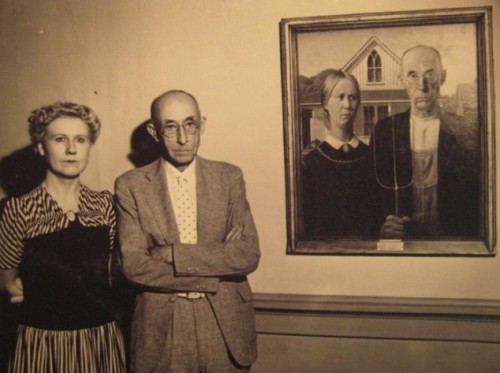 Nan Wood and Byron McKeeby – the artist&#8217;s sister and dentist respectively – pose next to Grant Wood&#8217;s painting, American Gothic (1930), in which their likenesses were used.