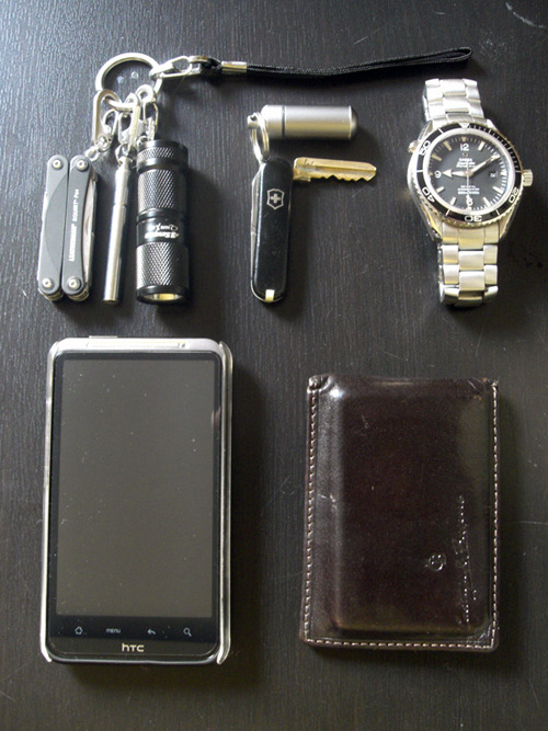 submitted Patrick

Finally got time to take a snap for this great site, Keep it up! From top left clockwise:-True Utility keyring system.-Leatherman Squirt PS4.-True Utility telescoping pen.-4Sevens Quark miniX 123.-Modified key SAK.-True Utility cashstash.-Omega Planet Ocean.-HTC Desire HD.-Leather cardholder.

Editor’s Note: Wow, cool keychain. Nice tools on it and the True Utility system makes everything modular and accessible. I’ve never seen someone use a wrist strap for their keychain carry, which I suppose makes it easy to access for people who pocket carry, right? Great SAKey mod too, you did a good job with that. Some unique stuff in here, thanks for sharing!