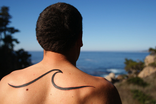 surfer with wave tattoo across back cool