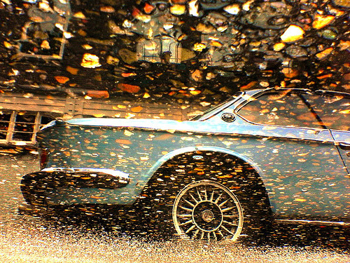 An Old School BMW reflected in a puddle