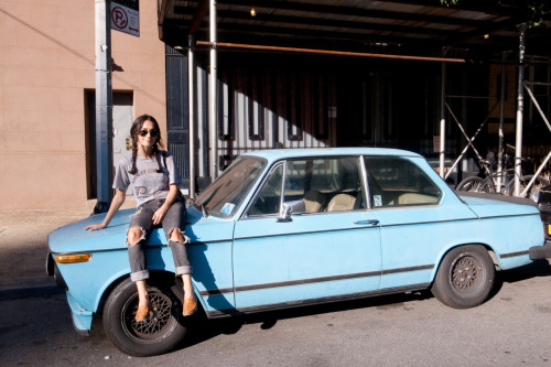 Audrey sitting on an old BMW