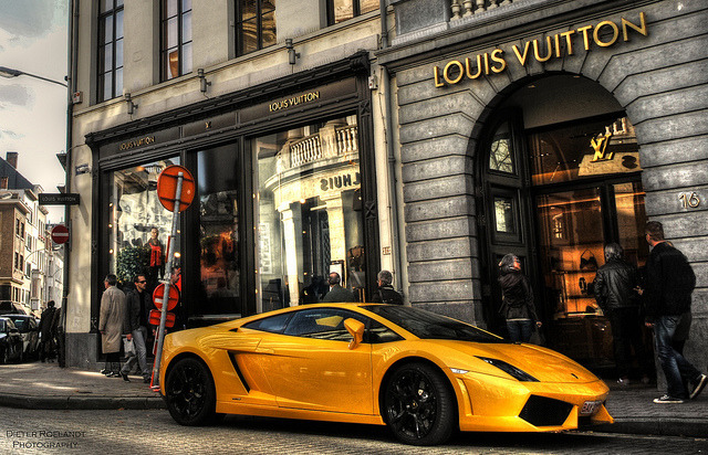 Yellow Lamborghini Gallardo LP5604 parked outside a Louis Vuitton store in