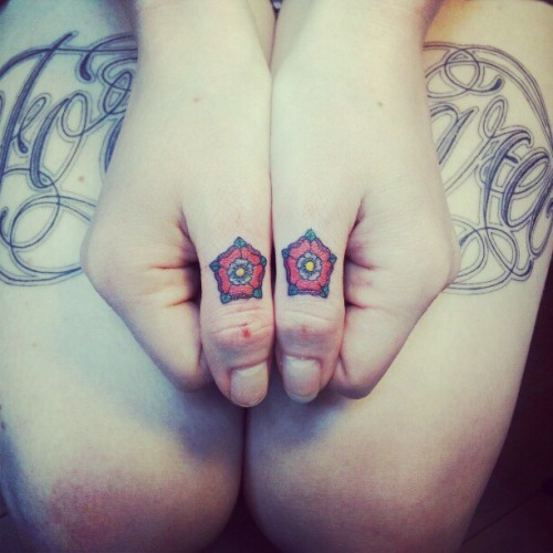 Thumb knuckle Tudor roses by Alie K at Archive Tattoo in Toronto