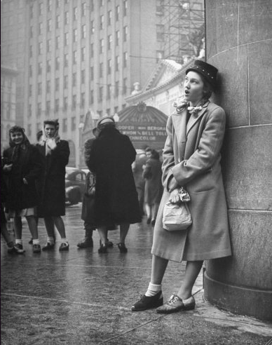 por Nina Leen, um adolescente canta em uma esquina, como parte de uma iniciação clube sub-deb sociais em 1945